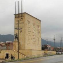 Torre rectangular de 6 pisos de altura, enchapada en piedra, con escalinatas sobre el frente, contra el cual se erige la escultura del libertador Simón Bolívar en su caballo.