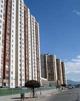 La imagen muestra dos conjuntos residenciales con torres de edificios muy altos, a su mano derecha una vía vehicular.