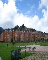 Imagen de un amplia zona verde en medio de un conjunto de apartamentos y un parque.  