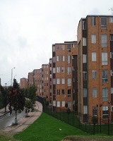 Imagen de conjunto residencial de apartamentos, a su lado izquierdo tiene una vía vehicular local y en su parte intermedia una pequeña zona verde. 