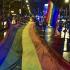 Gran bandera LGBTI extendida por varias personas en más de una cuadra de la calle