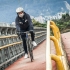 Biciusuario transitando por un puente.