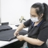 Mujer operaria de la industria textil cortando telas.