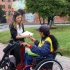 Jefe de la Oficina Asesora de Comunicaciones, Leidy Muñoz, entregando libro del Manual del Espacio Público a mujer en silla de ruedas.