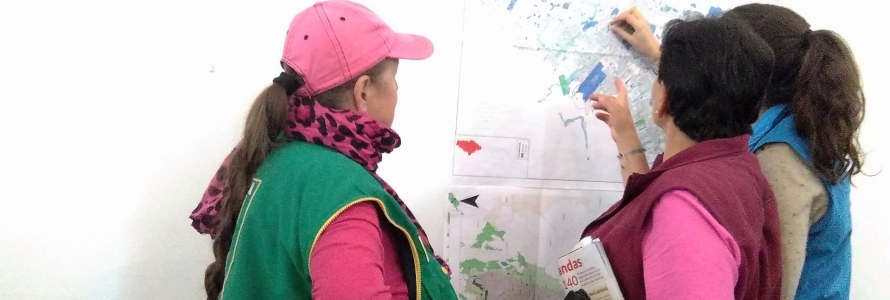 Mujeres asistentes a socialización POT realizando ejercicio sobre mapa en la pared