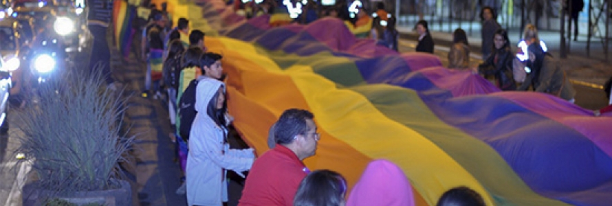 Ciudadanos extendiendo una gran bandera LGBTI que abarca varias calles