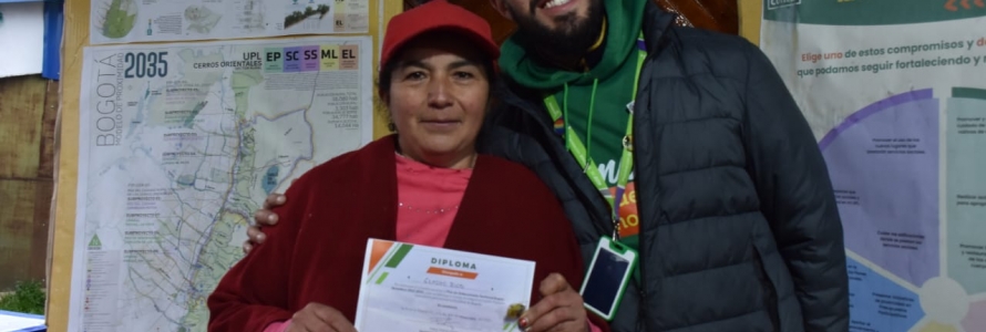 Funcionario de la Secretaría Distrital de Planeación con ciudadana que sostiene un diploma