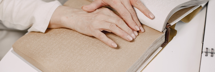 Manos de persona leyendo lenguaje Braille
