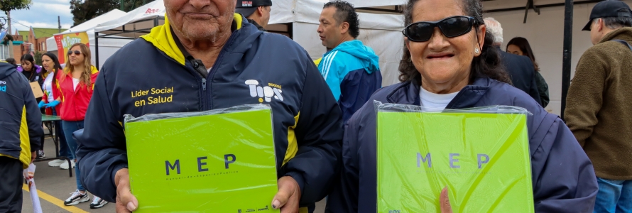 Ciudadano y ciudadana con libros del Manual del Espacio Público en sus manos.