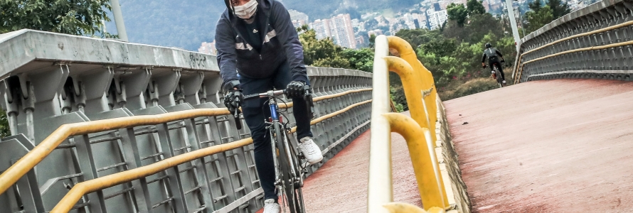 Biciusuario transitando por un puente.