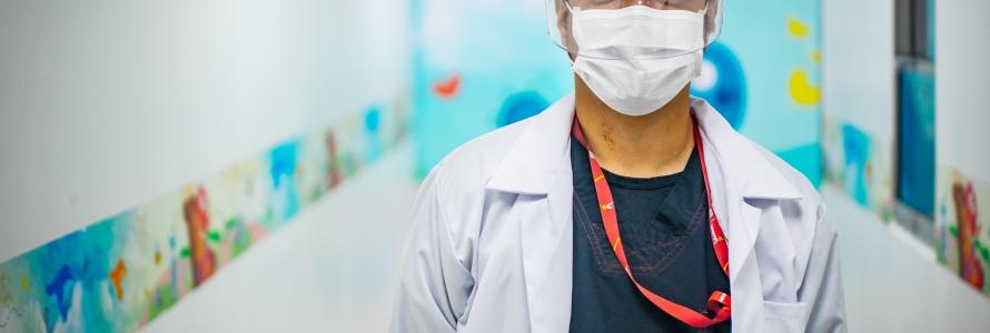 Médico con bata, tapabocas y careta