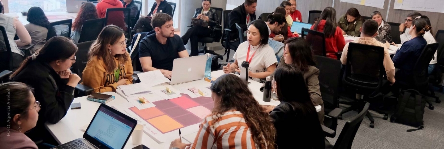 Personas reunidas en mesas de trabajo