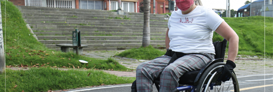  En la foto está Sandra (persona con discapacidad física) en su silla de ruedas recorriendo un parque.