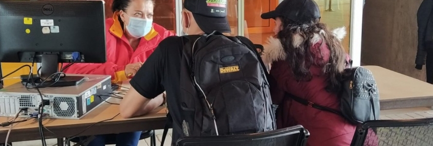 Funcionaria atendiendo a un ciudadano y a una ciudadana