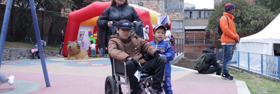 Mujer junto a joven en silla de ruedas y  niño